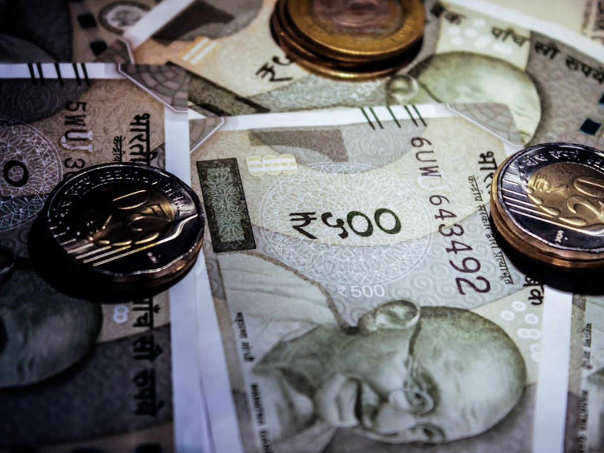 Indian currency notes and coins, including Rs 10 and Rs 20 denominations, arranged for visual clarity, optimized for accessibility.