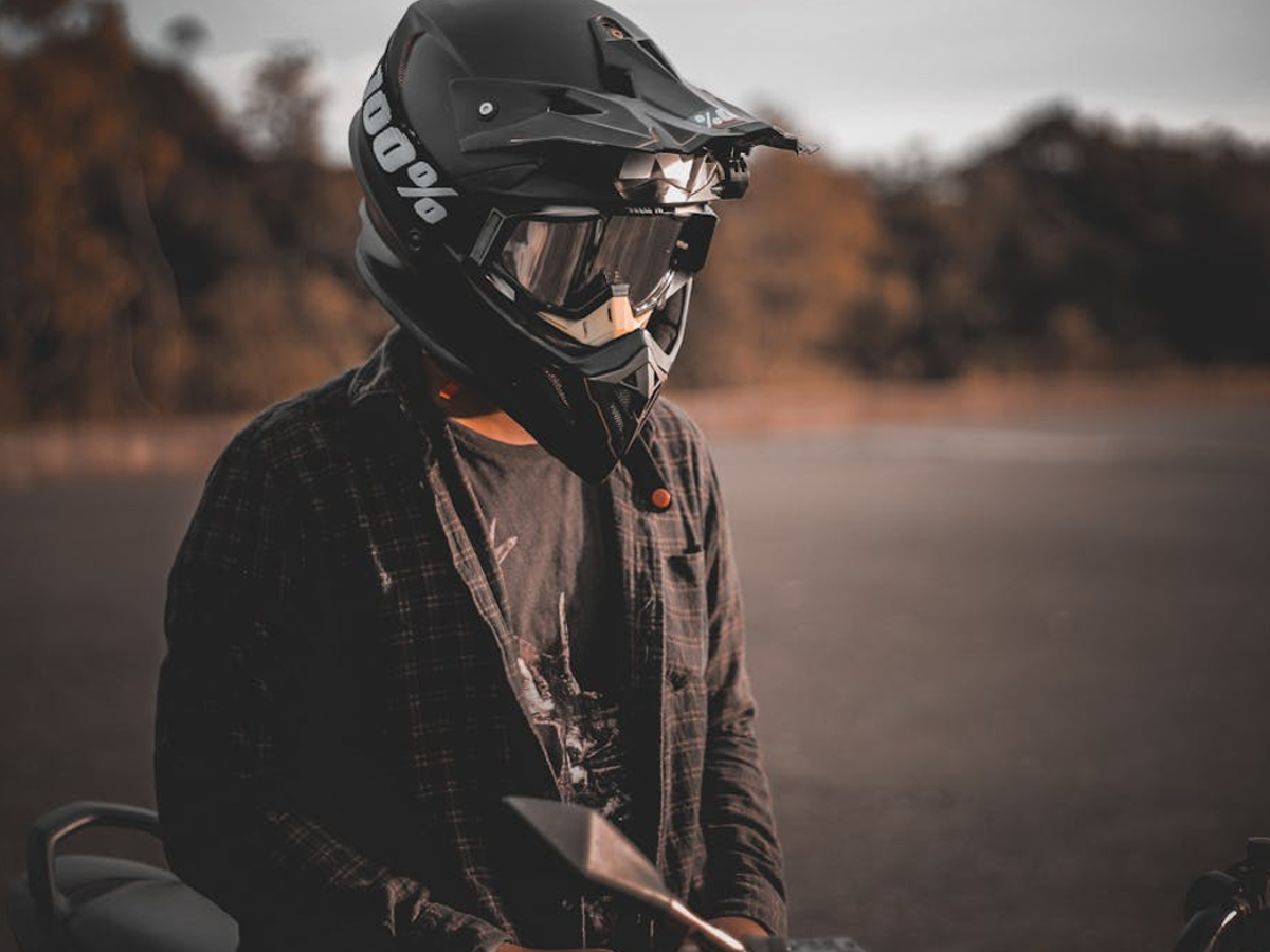 Motorcycle rider wearing a BIS-certified ISI-marked full-face helmet on a busy road, promoting road safety.