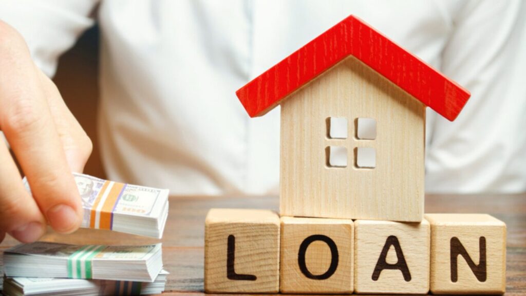 A person in Bengaluru holding home loan repayment documents like NOC and EC at a bank counter.