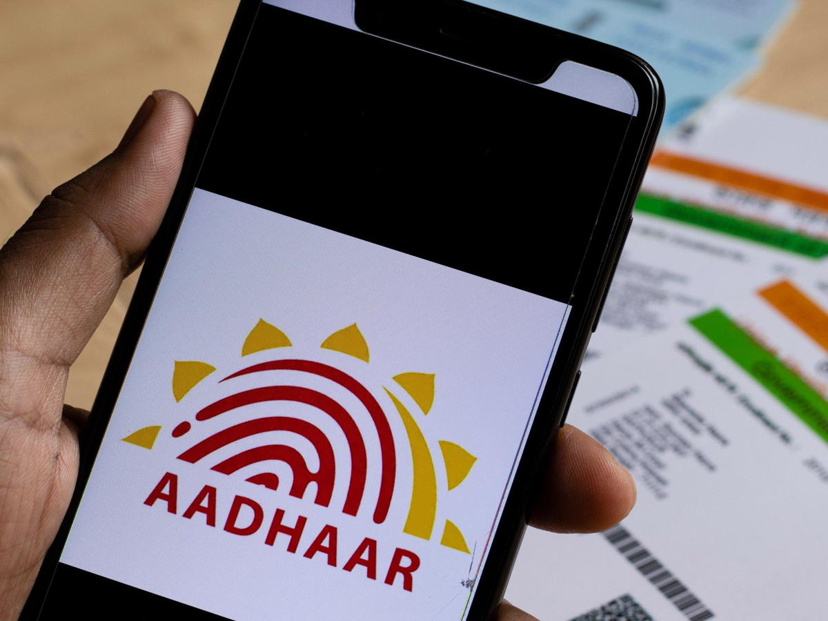 Parents updating child's Aadhaar at a seva kendra, showing documents and biometric scanning process.