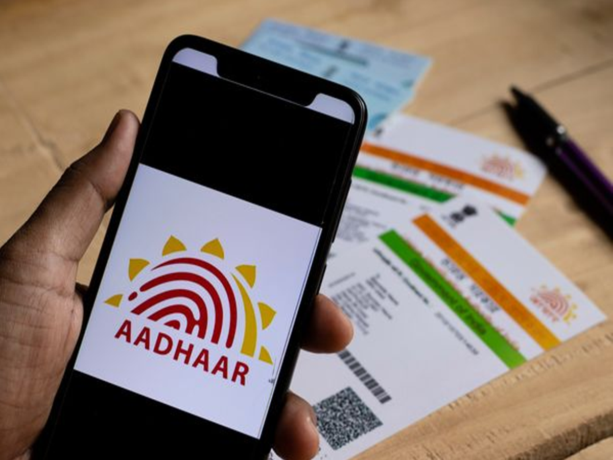 Aadhaar card and mobile phone placed together, symbolizing secure linking process.