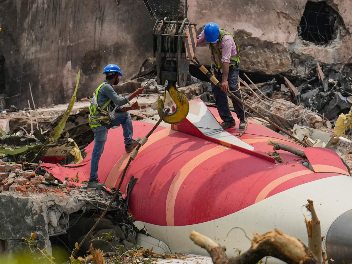 Wreckage of Air India Flight 171 crash in Ahmedabad, showing debris and emergency responders at BJ Medical College hostel.