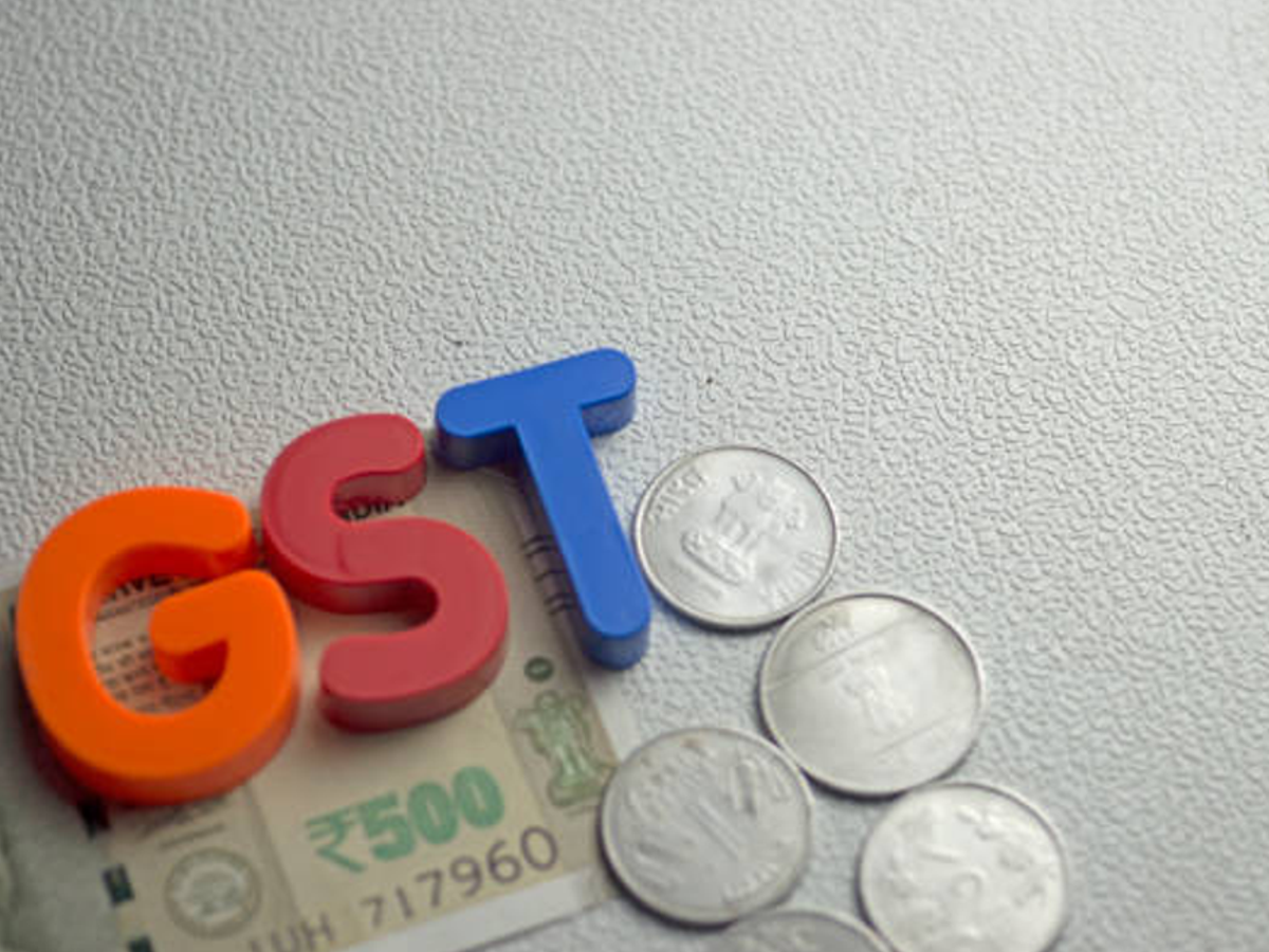 Image of luxury SUVs in a Bengaluru showroom with GST tax symbols