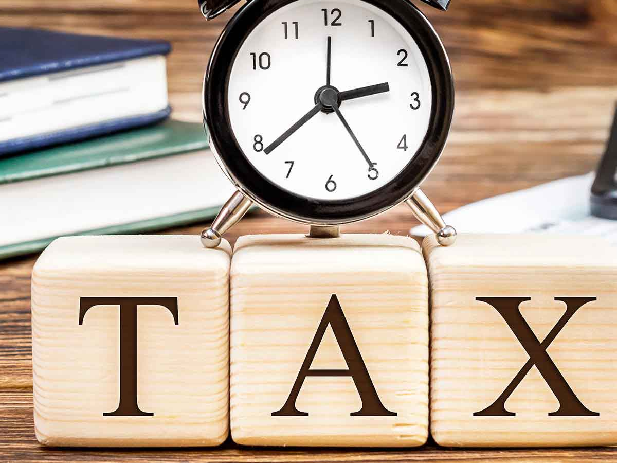 Person calculating tax penalties on computer, highlighting late fees and interest for missing ITR deadline.