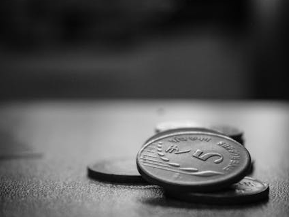 Visually impaired person handling Indian coins, showcasing tactile features for easy identification, optimized for accessibility.