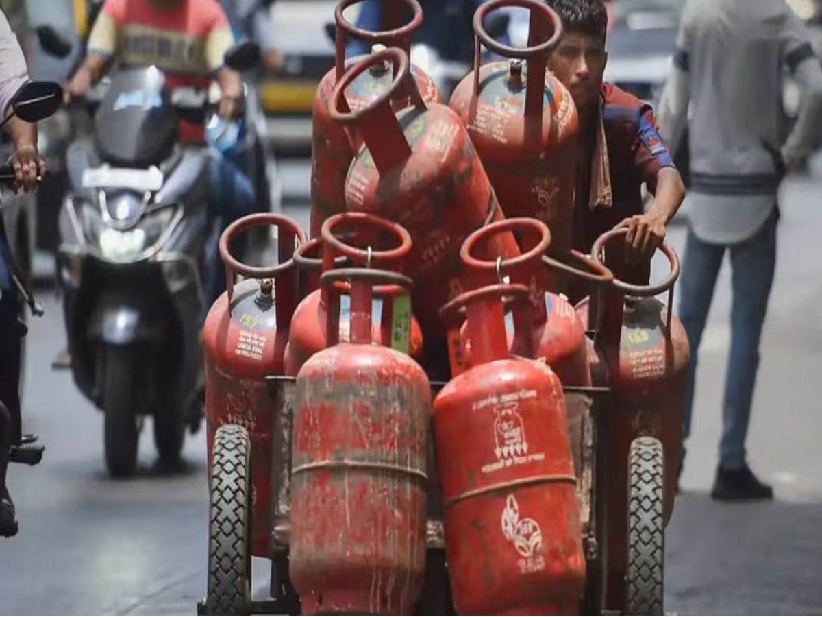 A person using a mobile app to book an LPG cylinder with a discount offer displayed.