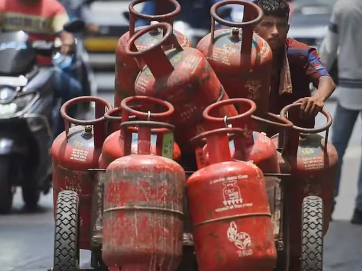 Stack of 19 kg commercial LPG cylinders at a distribution center, reflecting the ₹33.50 price cut effective August 1, 2025.