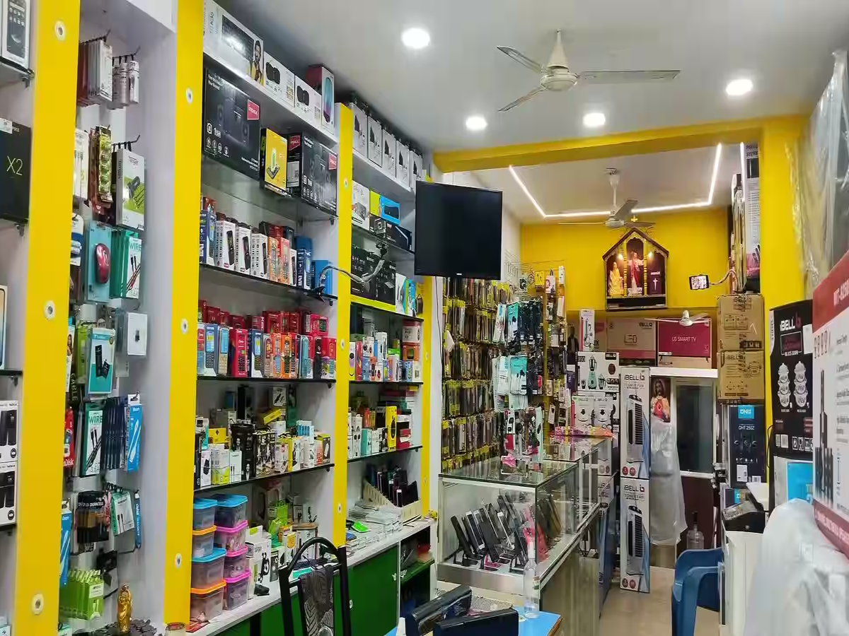 Illustration of GST reduction benefits with mobile phones, TVs, and refrigerators on a festive Deepavali background.