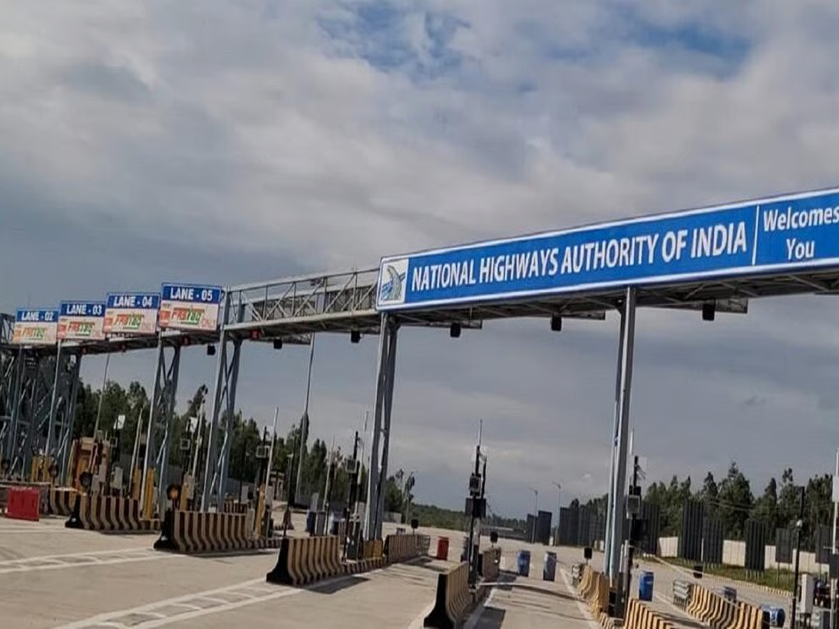 A vehicle passing through a toll plaza on the Delhi-Mumbai Expressway with FASTag signage.