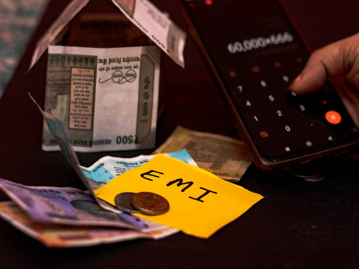 Image of a person reviewing EMI agreement terms with a magnifying glass for financial caution.