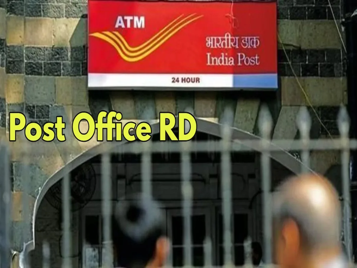 A person depositing money at a post office counter for the RD scheme, with a savings passbook in hand.