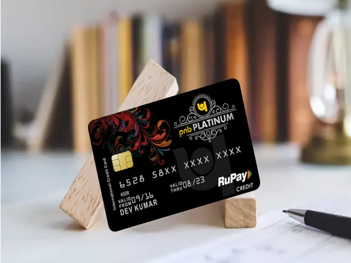 Person using a mobile phone for RuPay Credit Card UPI payment at a store.