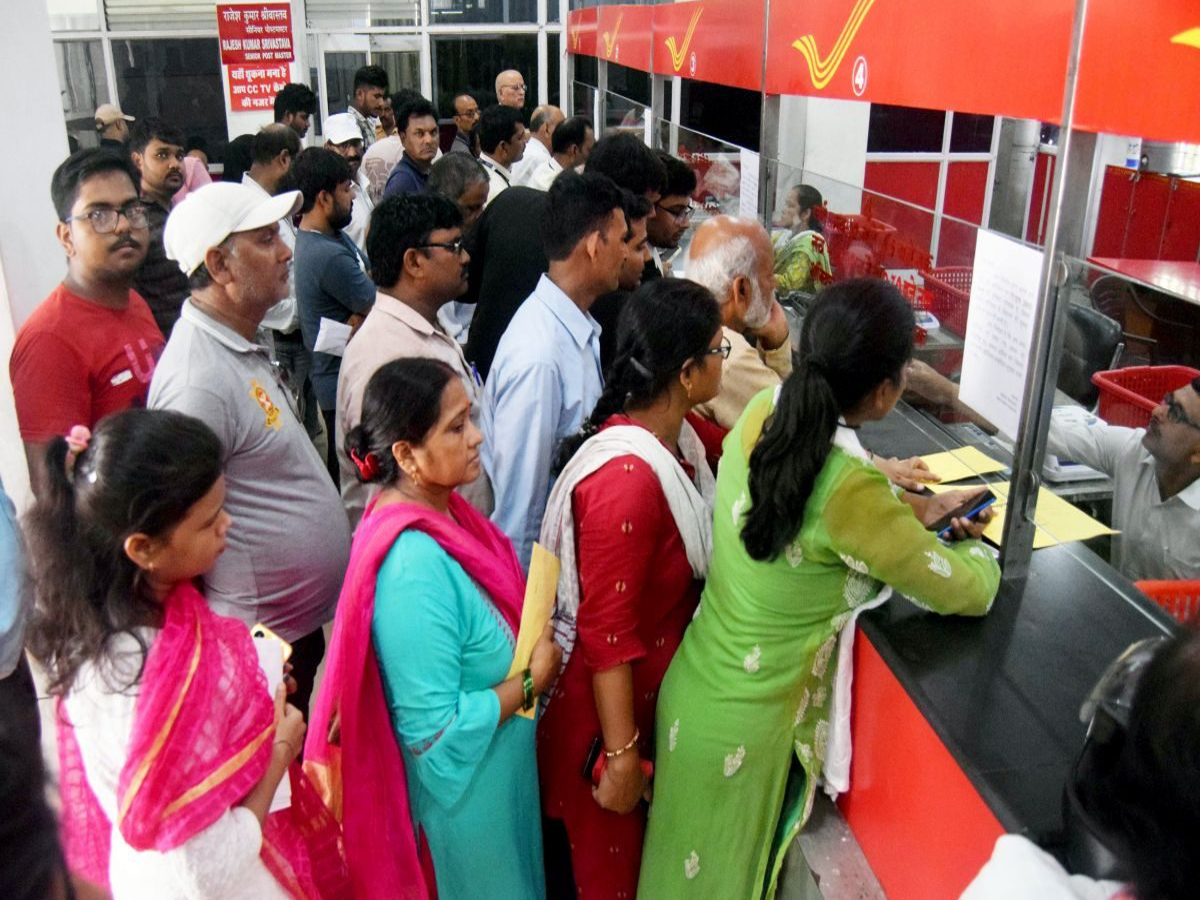 Indian woman holding a passbook at a post office