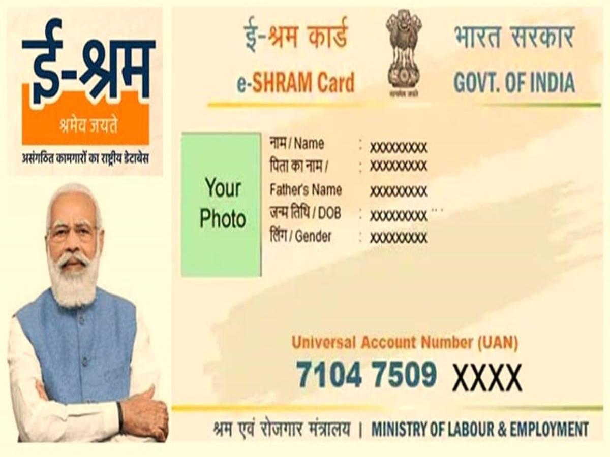 A group of Indian workers holding e-Shram cards, smiling, with a background of a construction site.