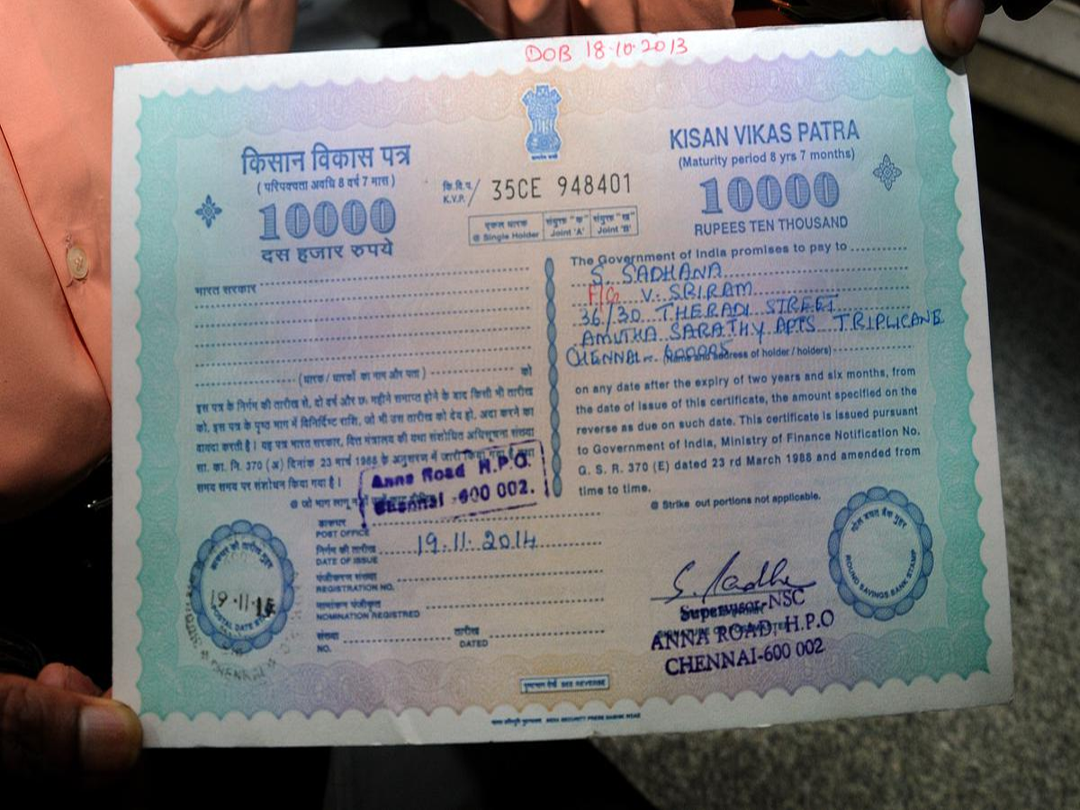 Kisan Vikas Patra certificate with a post office backdrop