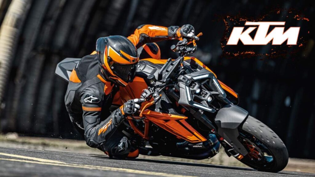 KTM 160 Duke bike in vibrant orange color on a city road, showcasing its sporty design.