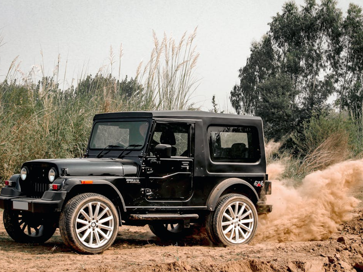 Mahindra Thar and Scorpio in action, depicting Thar’s off-road capability and Scorpio’s on-road comfort.