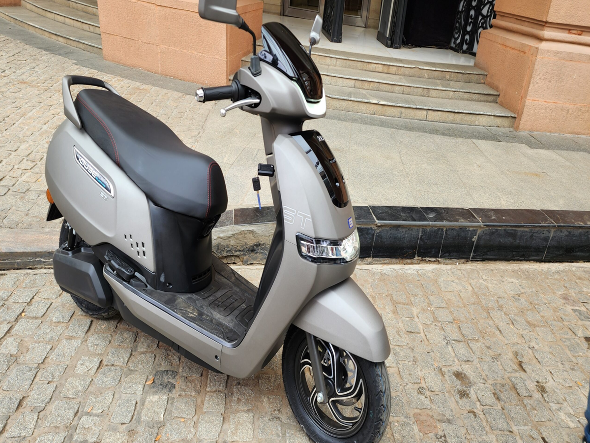 TVS iQube Electric and Ola S1 Air scooters side by side in a city setting