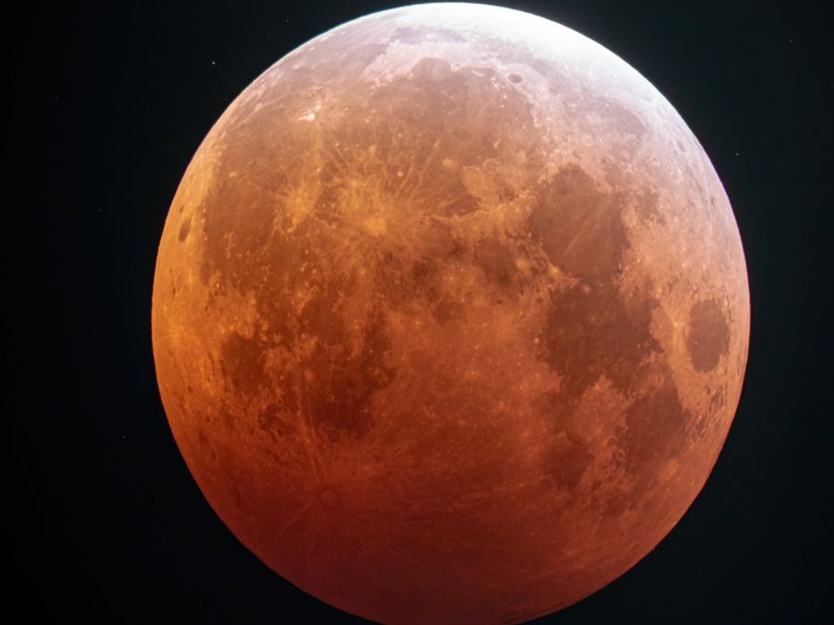 A serene scene of a person meditating under the moon during the 2025 lunar eclipse, symbolizing spiritual calm.